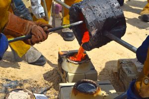 Pouring molten iron into a mold